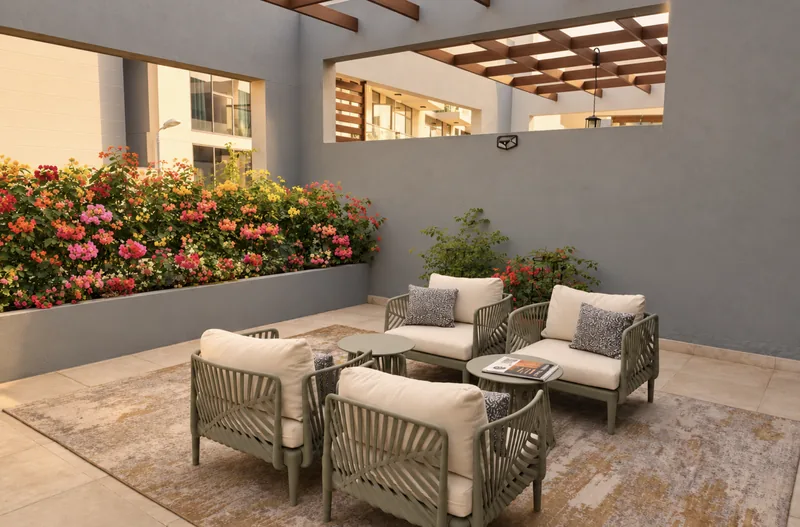 Dunia courtyard seating with four cushioned armchairs, low tables and raised beds of pink and orange bougainvillea