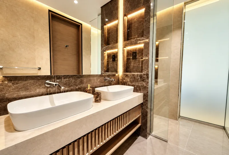 ParkView bathroom with double vessel basins on a fluted-oak vanity, dark marble niches and glass shower
