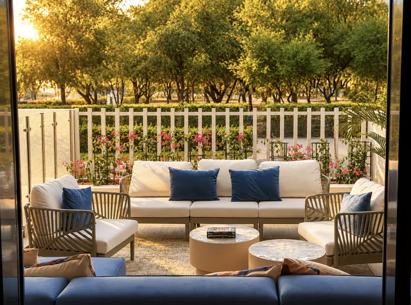 ParkView garden terrace seating with blue cushions behind a white picket fence and the park's trees