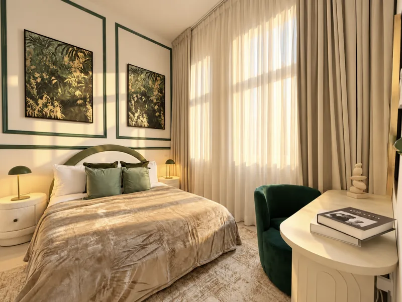 Yasmin bedroom with green trim, botanical artwork and green velvet chair at a desk