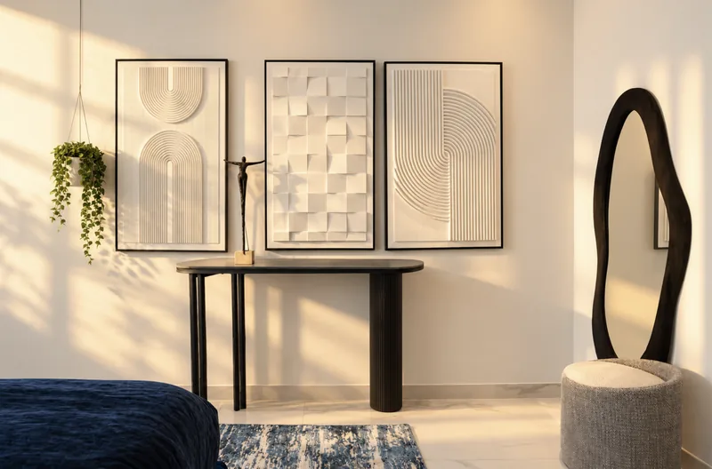 Zephyr bedroom console with three textured white prints and a black sculptural mirror