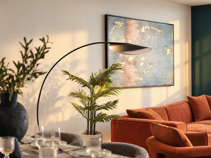 Zephyr living room detail with rust sofa, arc lamp and abstract artwork